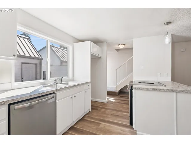 a kitchen with a sink cabinets and wooden floor