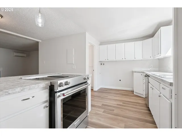 a kitchen with a stove oven and white cabinets