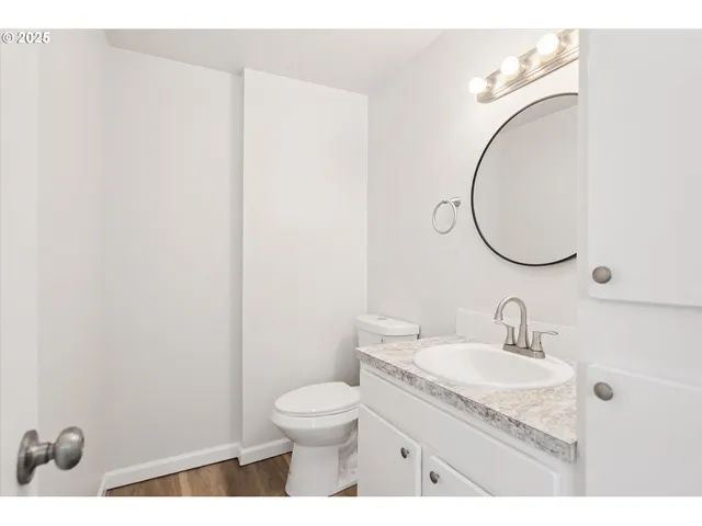 a bathroom with a granite countertop sink toilet and a mirror