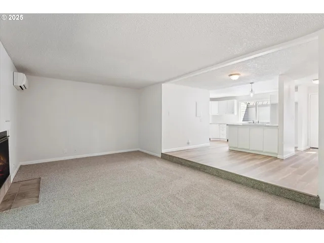 a view of an empty room and kitchen view