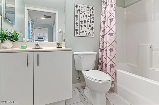 a bathroom with a granite countertop toilet and a sink