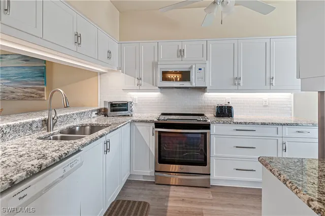 a kitchen with stainless steel appliances granite countertop a sink stove and cabinets