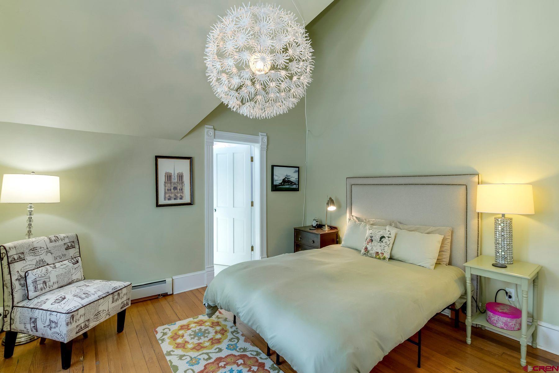 721 Maroon Avenue Crested Butte, CO 81224 - Photo 14 of 31 a bedroom with a bed and a chandelier