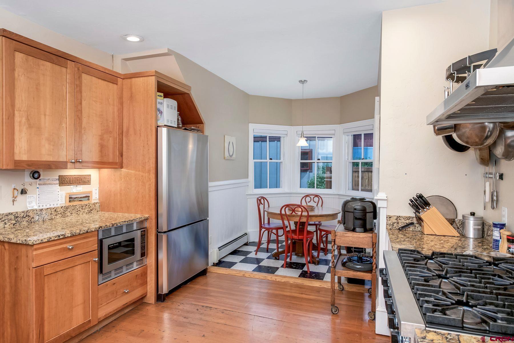 721 Maroon Avenue Crested Butte, CO 81224 - Photo 7 of 31 a kitchen with stainless steel appliances granite countertop a refrigerator and wooden cabinets