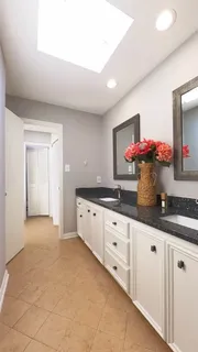 a kitchen with granite countertop white cabinets and sink