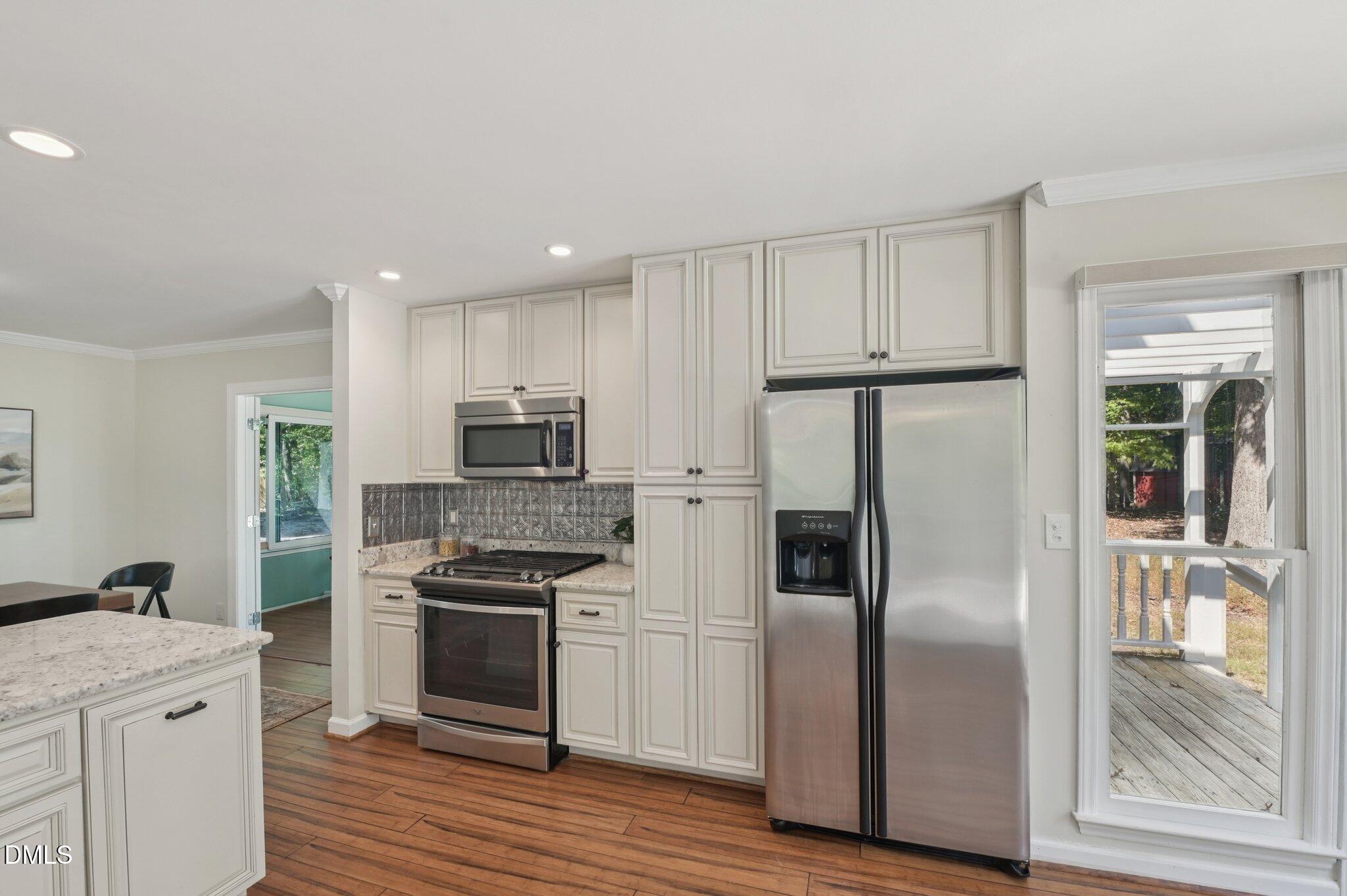 5965 Dunbarton Way Raleigh, NC 27613 - Photo 8 of 30 a kitchen with stainless steel appliances granite countertop a refrigerator and a stove top oven