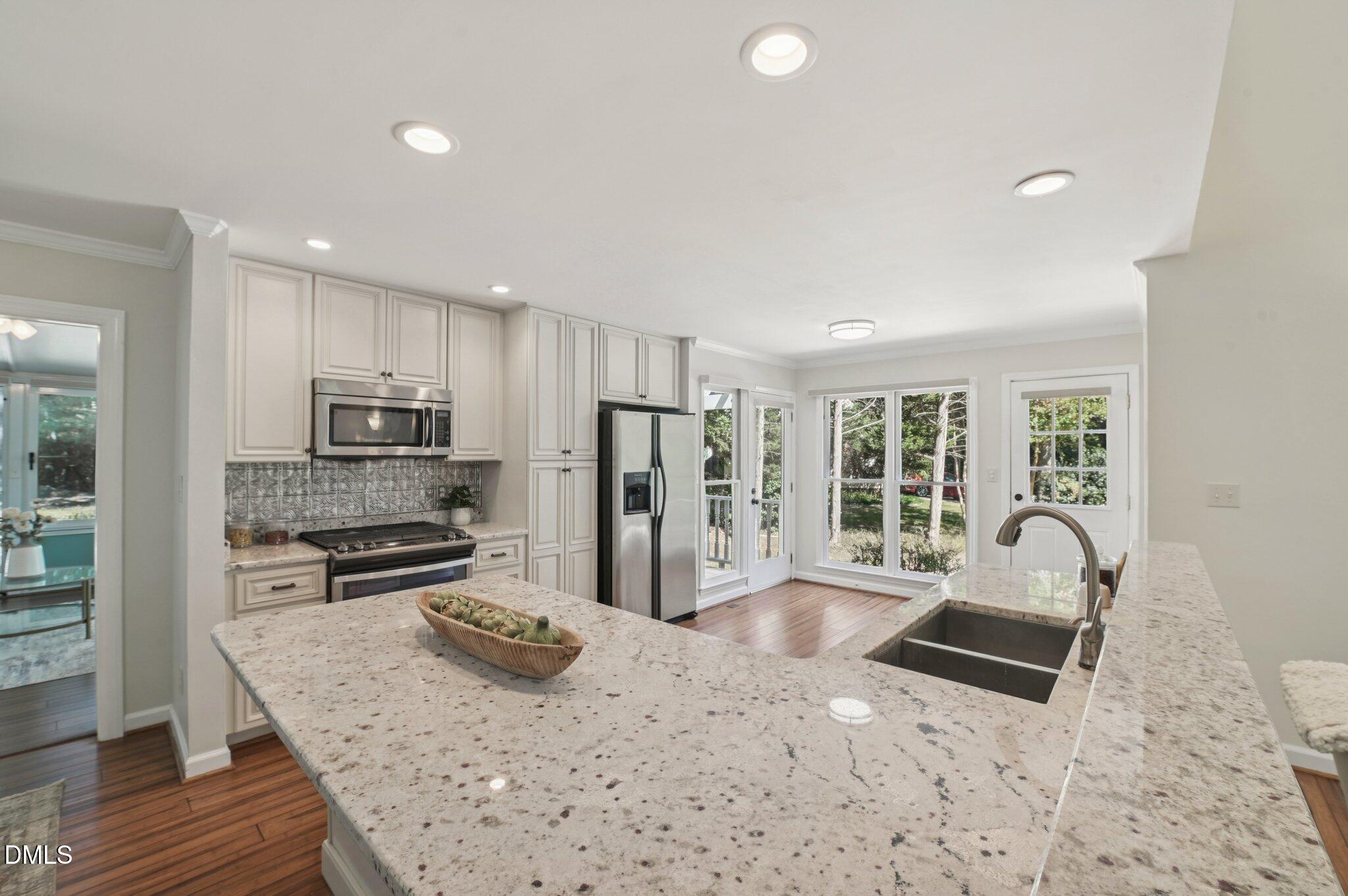 5965 Dunbarton Way Raleigh, NC 27613 - Photo 9 of 30 a kitchen with stainless steel appliances granite countertop a sink refrigerator and microwave