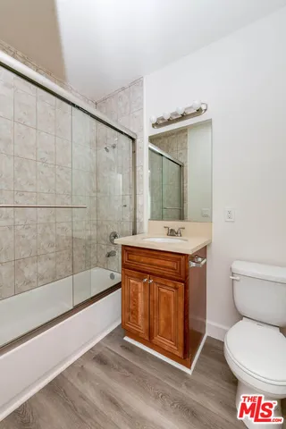 a bath room with a toilet a sink and a mirror