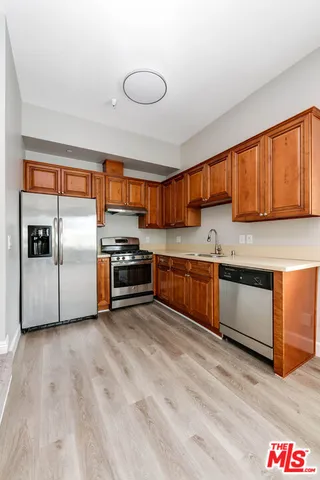 a kitchen with stainless steel appliances kitchen island granite countertop a stove a sink and a refrigerator