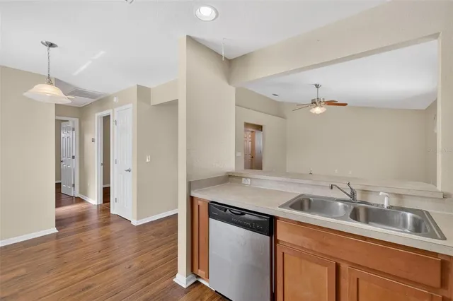 a kitchen with a sink cabinets and wooden floor
