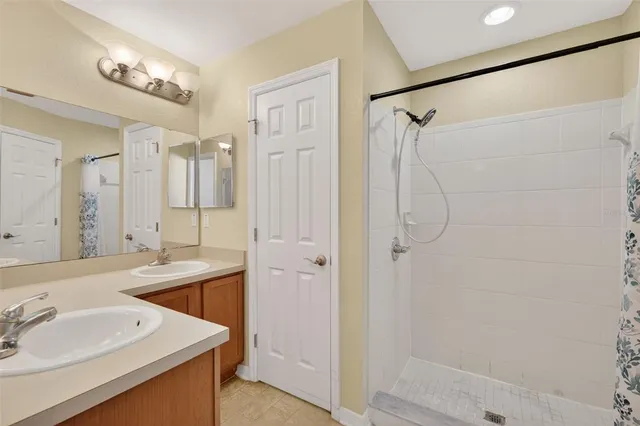 a bathroom with a shower sink and mirror