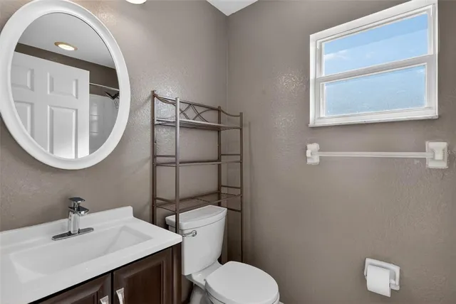 a bathroom with a toilet a sink and mirror