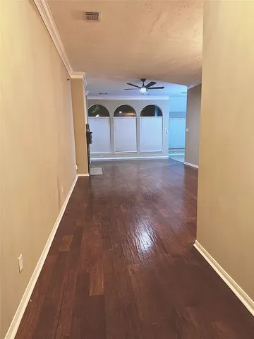 a view of empty room with wooden floor