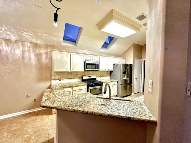 a kitchen with counter top space and stainless steel appliances