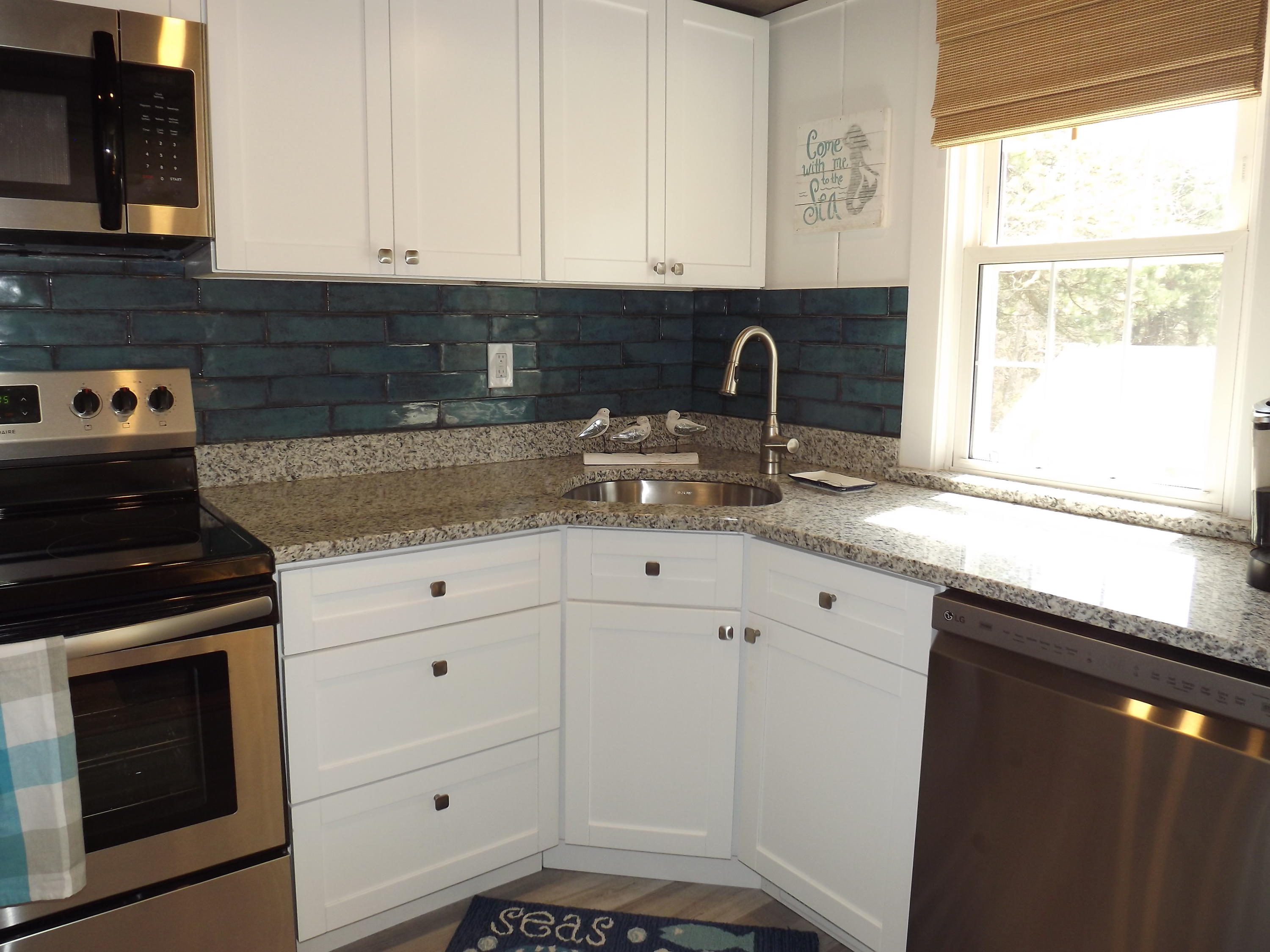 36 Tobey Turtle Road South Chatham, MA 02659 - Photo 8 of 21 a kitchen with granite countertop white cabinets and black appliances