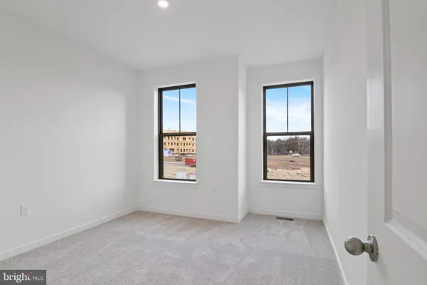 an empty room with windows and closet