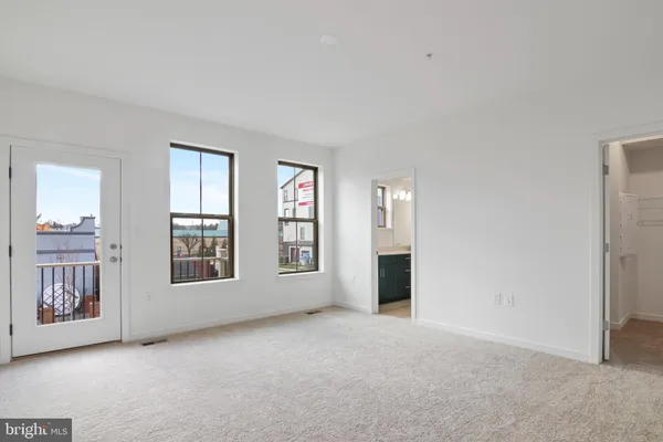 an empty room with windows and closet