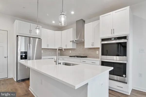 a kitchen with stainless steel appliances a stove a sink and a refrigerator