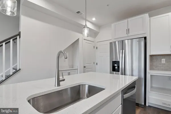 a kitchen with stainless steel appliances granite countertop a sink a refrigerator and a granite counter tops