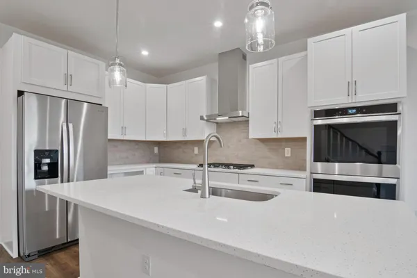 a kitchen with stainless steel appliances a sink a stove a microwave and cabinets