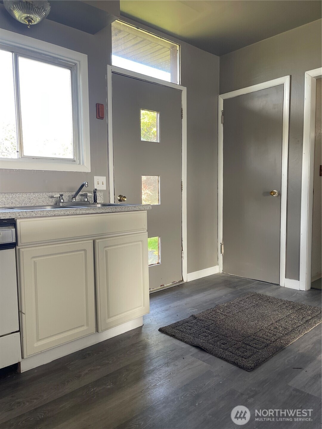 409 2nd Avenue Aberdeen, WA 98520 - Photo 5 of 7 a view of a kitchen with white cabinets and wooden floor