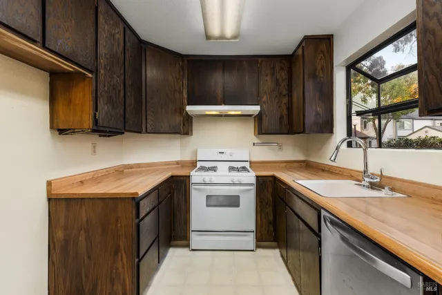 a kitchen with a stove sink and cabinets