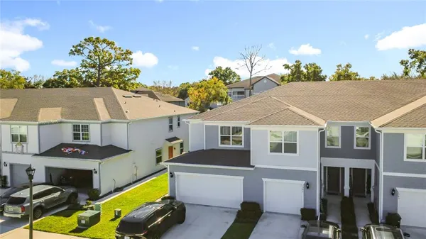 a front view of house with yard and trees in the background