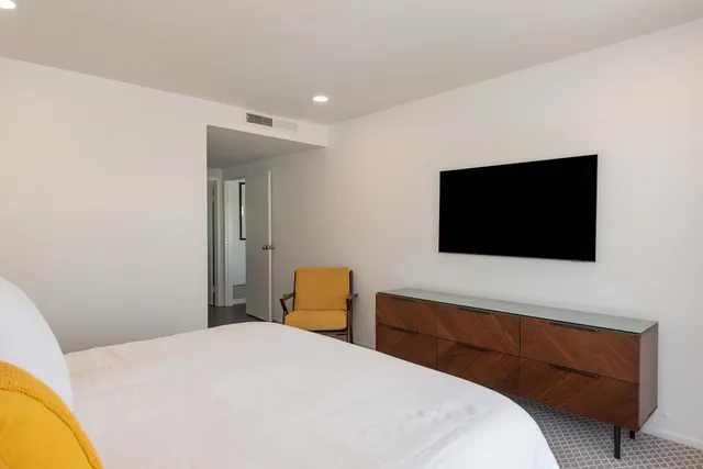 a bedroom with a bed and a flat screen tv