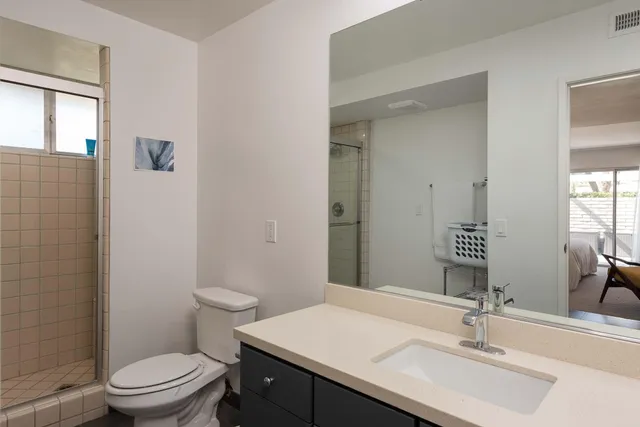 a bathroom with a sink a toilet and shower