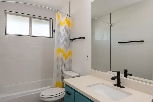 a view of a swimming pool with a lawn chairs under an umbrella