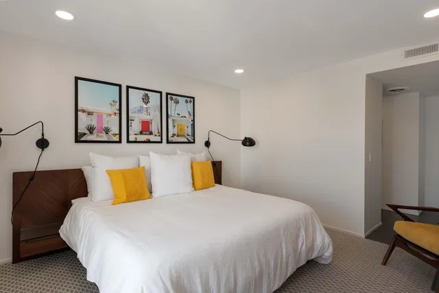 a bedroom with a bed and a painting on the wall