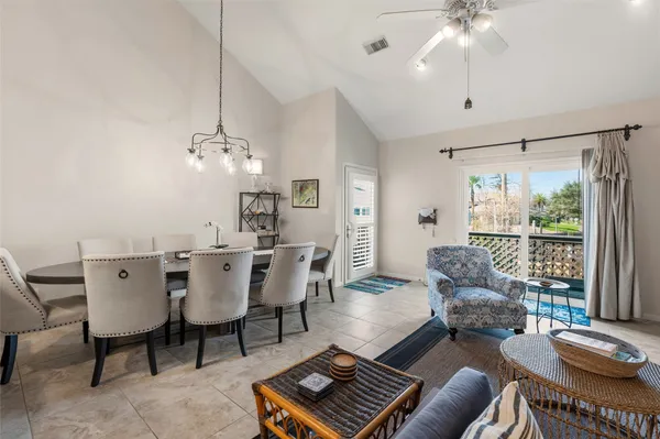 a living room with furniture a chandelier and a dining table