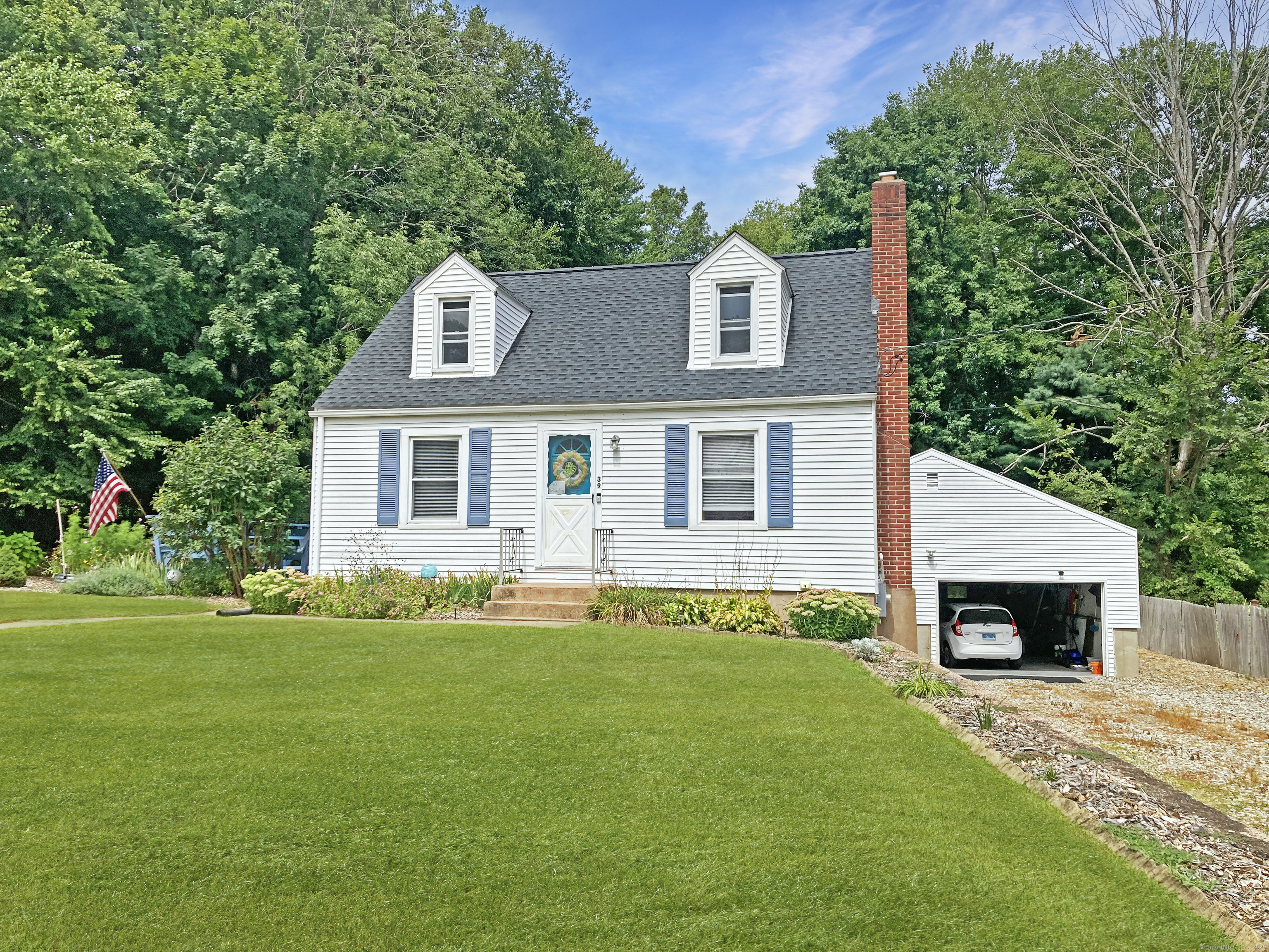 a front view of a house with a garden and yard