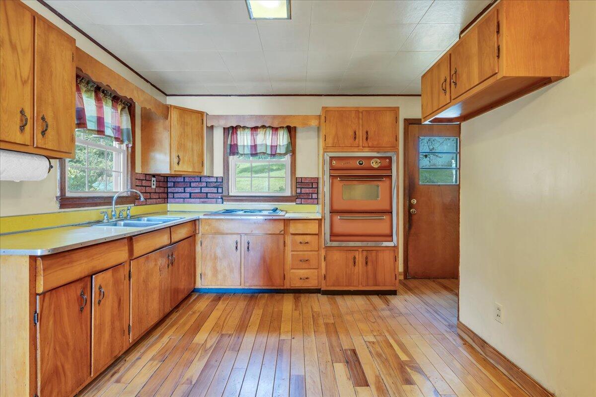 201 Long Avenue Covington, VA 24426 - Photo 9 of 43 a kitchen with wooden floors and white stainless steel appliances