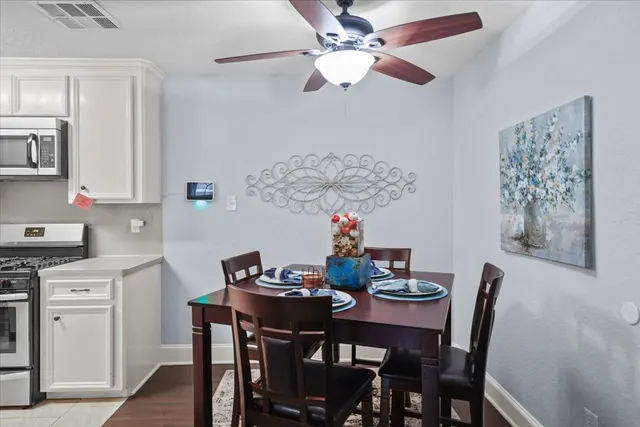 a view of a dining room with furniture and a chandelier fan