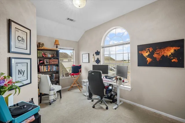 a view of a workspace with furniture and a window