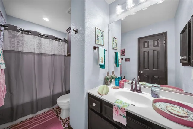 a bathroom with a granite countertop sink vanity mirror and shower