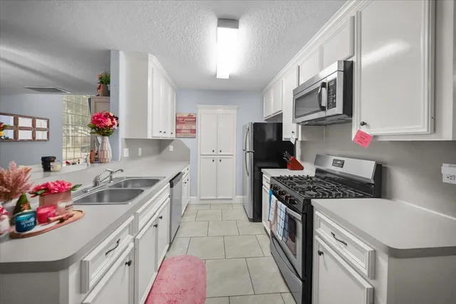 a kitchen that has a sink and a stove in it