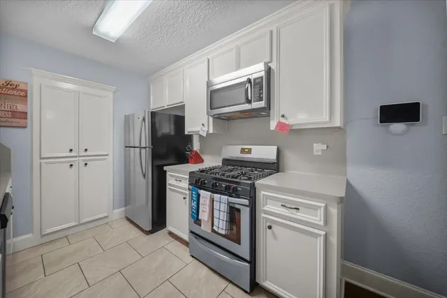 a kitchen with stainless steel appliances granite countertop a stove a refrigerator and a microwave