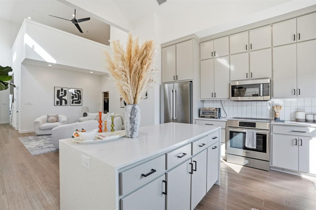 1301 Tillery Court Grapevine, TX 76051 - Photo 27 of 28 a kitchen with stainless steel appliances a sink stove refrigerator and cabinets