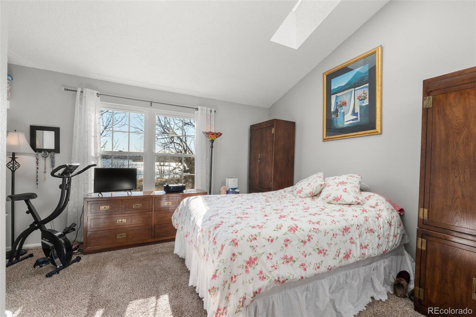 17467 East Rice Circle, Unit C Aurora, CO 80015 - Photo 17 of 25 a bedroom with a bed a computer on table and a window