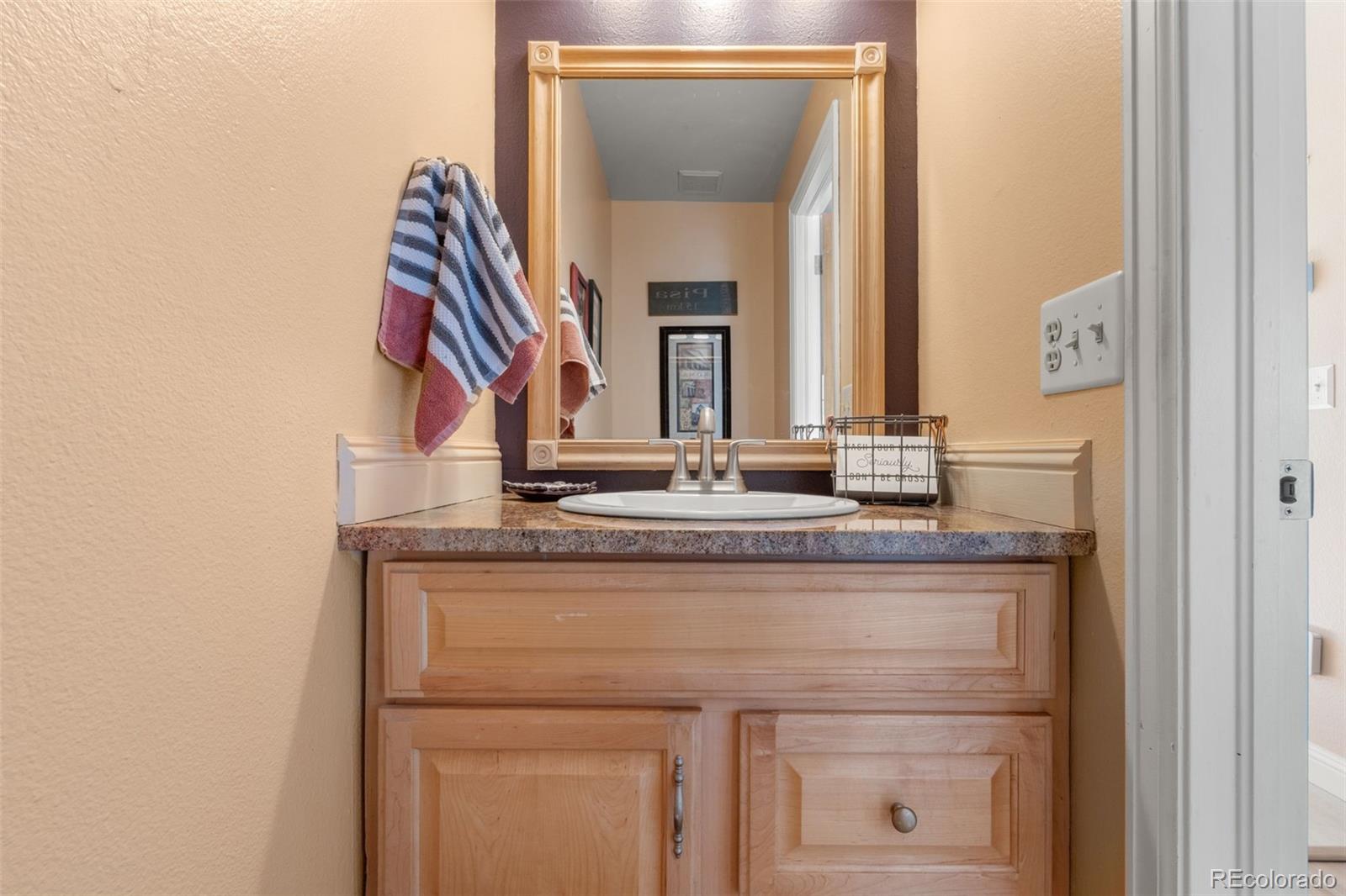 17467 East Rice Circle, Unit C Aurora, CO 80015 - Photo 7 of 25 a bathroom with a granite countertop sink and a mirror