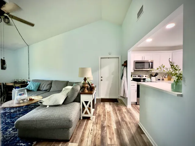 a living room with furniture and a wooden floor