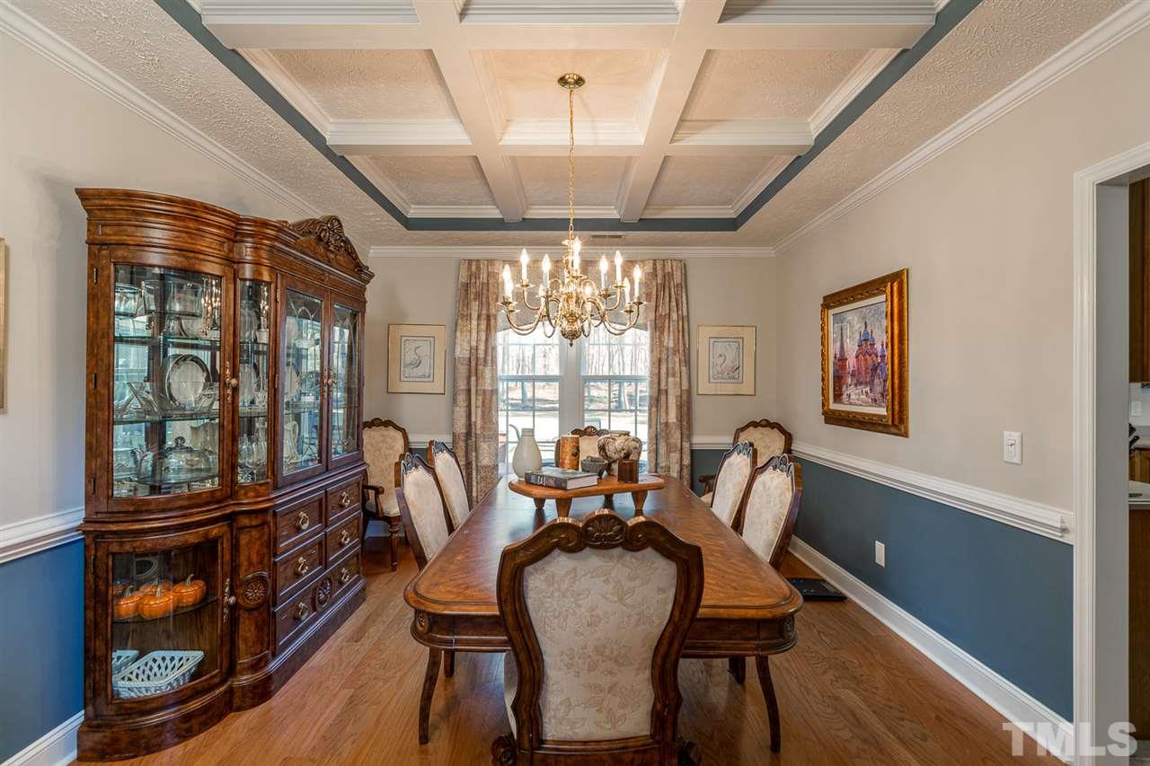 684 Alderman Mill Road Dunn, NC 28334 - Photo 8 of 30 a dining room with wooden floor a chandelier a wooden table and chairs