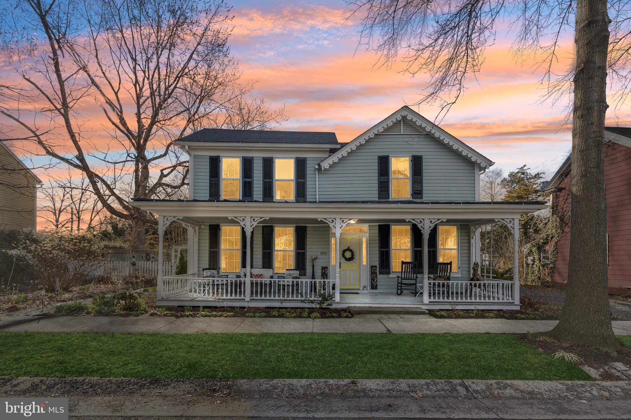 a front view of a house with a garden and trees