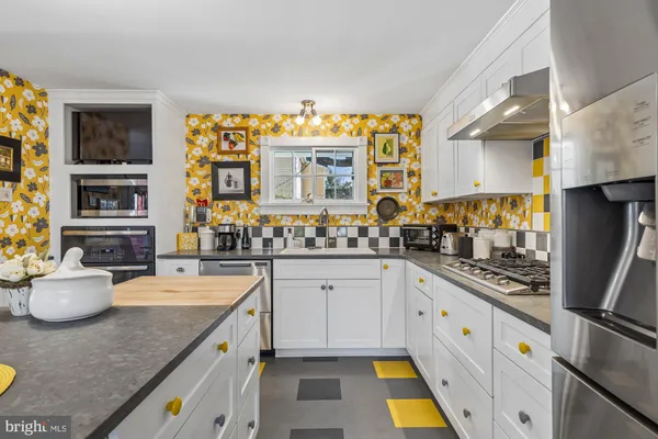 a kitchen with stainless steel appliances granite countertop a sink stove and cabinets