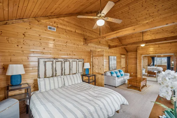 a bedroom with a bed a chandelier and flat screen tv