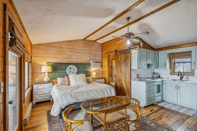 a bedroom with a bed and wooden floor