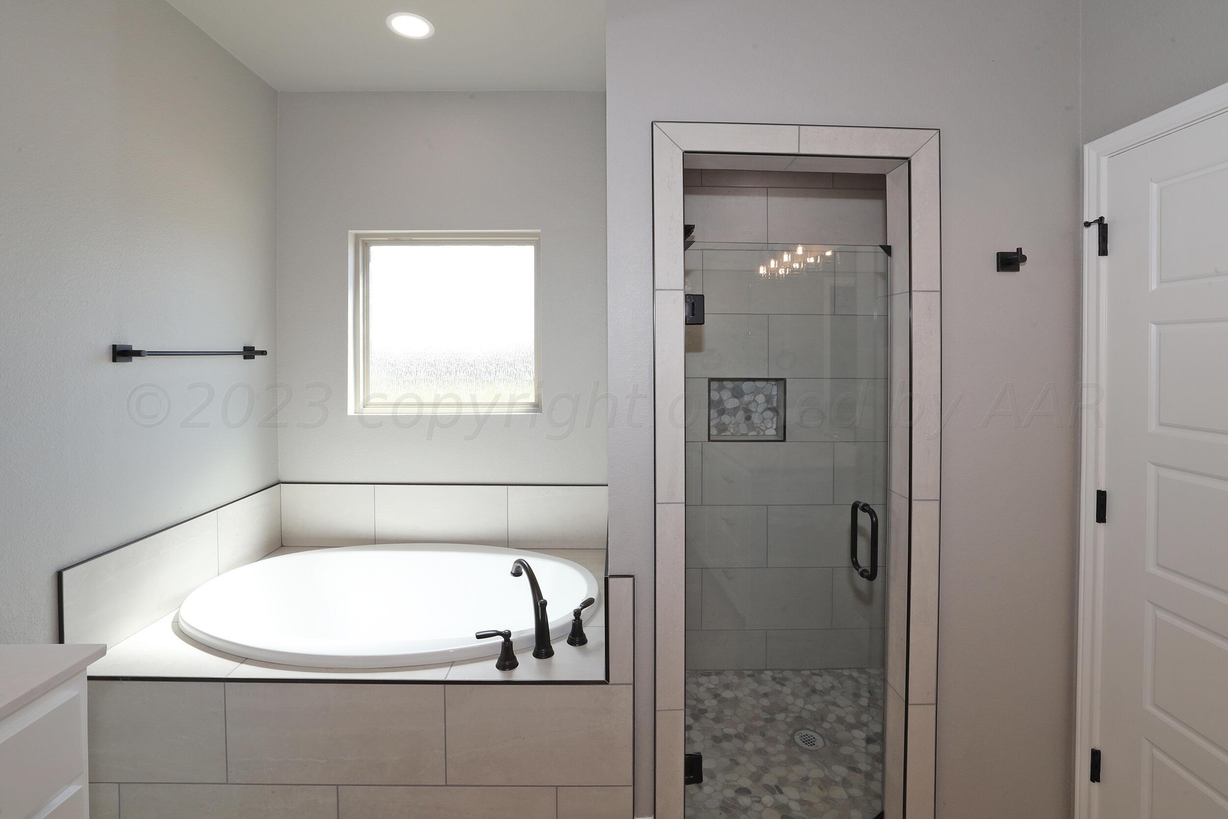 9551 Trinity Drive Amarillo, TX 79119 - Photo 12 of 46 a bathroom with a tub and shower