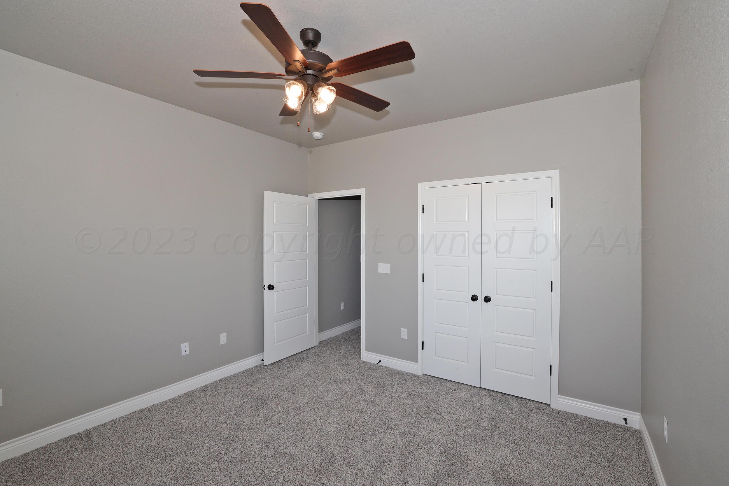 9551 Trinity Drive Amarillo, TX 79119 - Photo 14 of 46 an empty room with closet and a chandelier fan